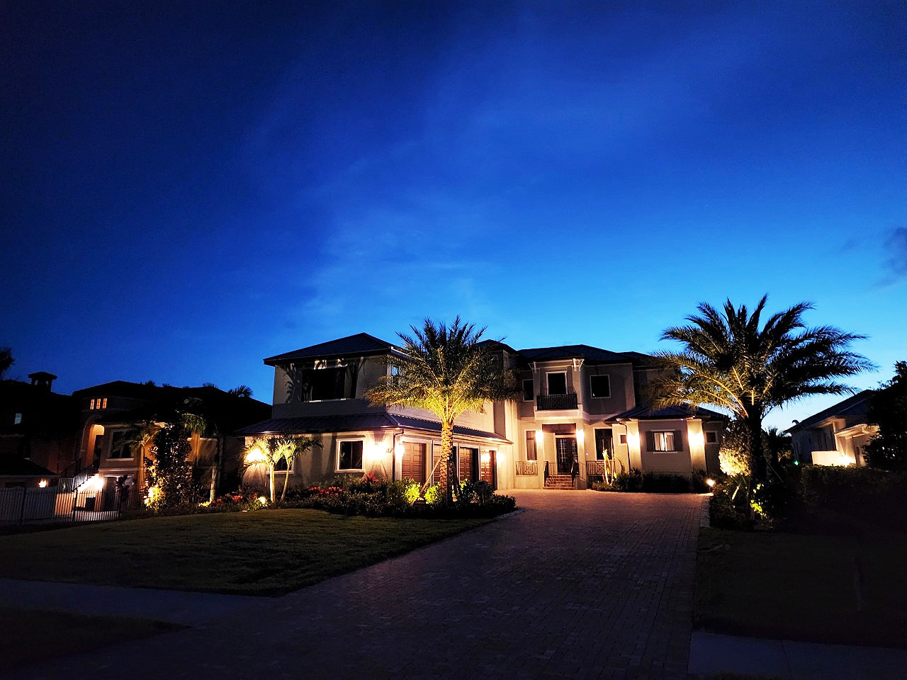 Exterior lighting installation on a Florida home and palms